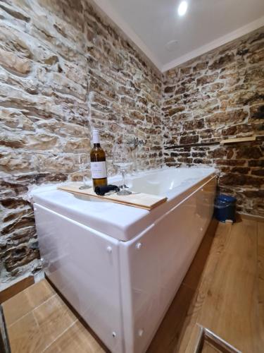 a bottle of wine sitting on top of a bath tub at "Villa 70" Guesthouse in Gjirokastër
