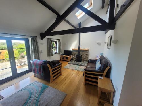 a living room with wooden floors and a ceiling with beams at Long Linhay in Woolacombe
