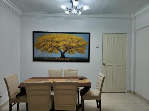 a dining room with a table and a yellow tree at NAHARA HOMESTAY Carlina in Petaling Jaya