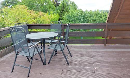 a table and two chairs sitting on a deck at Schöner Blick 