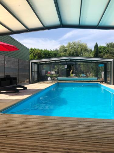 - une piscine dans une maison avec un bâtiment dans l'établissement Évasion du préhaut, à Tournehem
