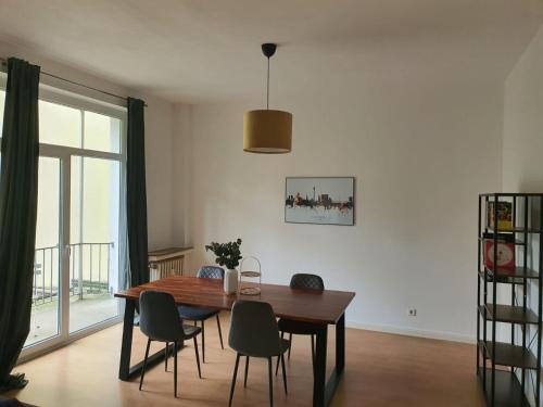 a dining room with a wooden table and chairs at Spacious 70sqm apt in popular location in Düsseldorf