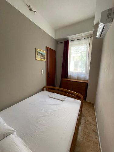 a bedroom with a bed in a room with a window at Teen Hub in Ermoupoli