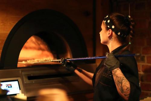a woman is taking something out of a oven at Apartamenty Chełmińskie in Chełmno