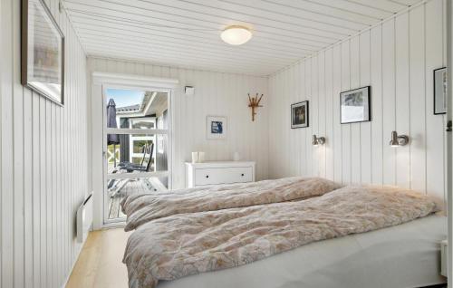 a bedroom with white walls and a large bed at Nice Home In Fan With Kitchen in Fanø