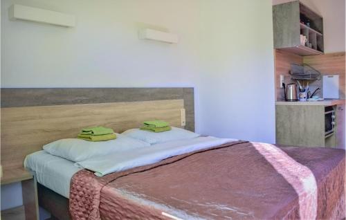 Una cama con dos toallas verdes encima. en Gorgeous Apartment In Rowy With Wifi en Rowy