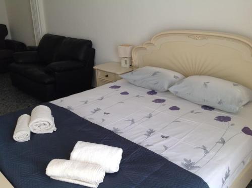 a bedroom with a bed with towels and a chair at Aegean colors apartment in Marmarion