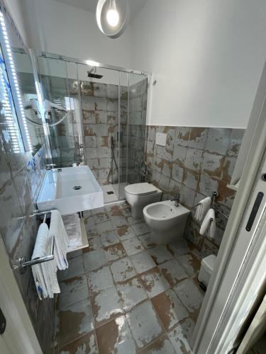 La salle de bains est pourvue d'un lavabo, de toilettes et d'une douche. dans l'établissement B&B Centro Storico, à Diamante
