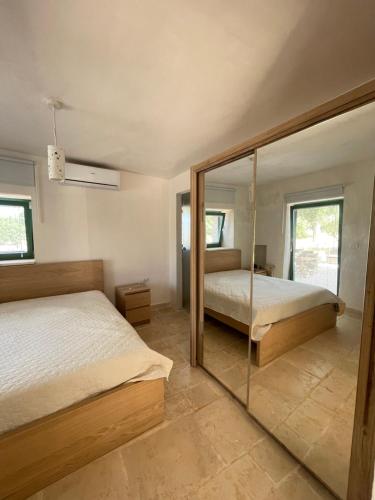 a bedroom with two beds and a glass wall at Lamia Millanta in Villanova di Ostuni