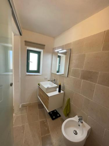 a bathroom with a sink and a toilet and a mirror at Lamia Millanta in Villanova di Ostuni