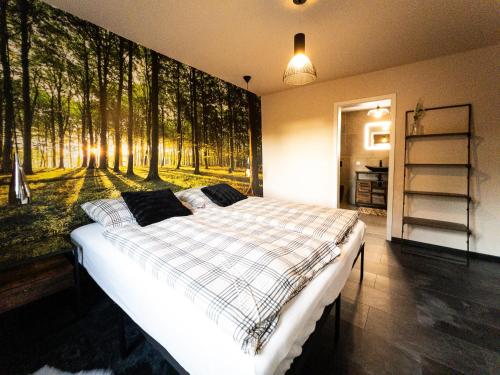 a bedroom with a bed with a painting of trees at Ka:Ma Hof Uckermark in Carmzow