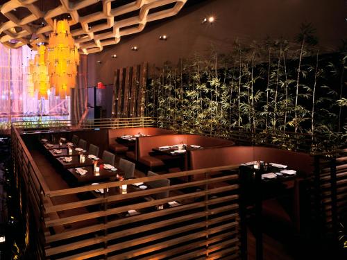 a dining room with tables and a chandelier at Bryant Park Hotel in New York