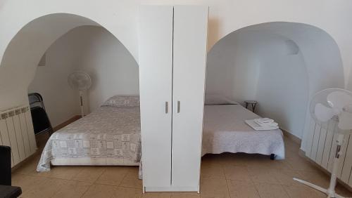 sypialnia z łóżkiem i dwoma białymi łukami w obiekcie Trullo Alberobello Vacanze Desà 1 w Alberobello