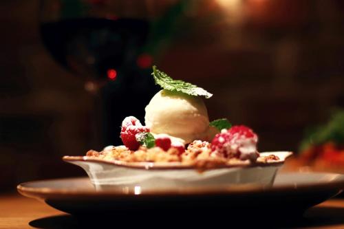 a dessert with a scoop of ice cream on a plate at Apartamenty Chełmińskie in Chełmno