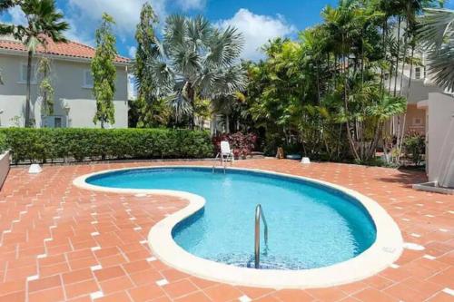 a swimming pool in a yard with trees and a building at Tranquil Townhome, close to beach & dining in Saint James