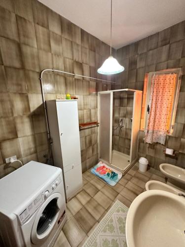 a bathroom with a washing machine and a sink at Sa Domu de Cri in Giba