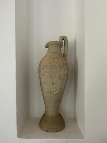 a vase sitting on a shelf in a white wall at Villa Le Domaine Djerba Piscine Chauffée sans vis à vis in Mezraya