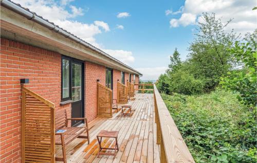 a wooden deck with benches on the side of a building at Lovely Apartment In Svaneke With Wifi in Svaneke