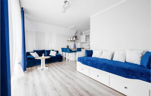 a bedroom with a blue bed and a living room at 1 Bedroom Amazing Apartment In Darlówko in Darłówko