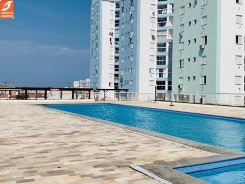 a swimming pool in front of some tall buildings at Apartamento próximo a praia. in Laguna