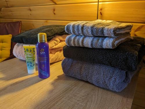 a pile of towels and a bottle of shampoo on the floor at Luxe glamping "De Steenuil" met sauna in Volkel