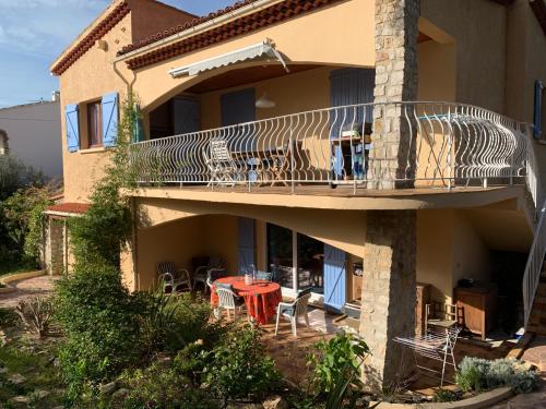 un balcon d'une maison avec une table et des chaises dans l'établissement Les Embruns Maison Appartement, à Saint-Mandrier-sur-Mer