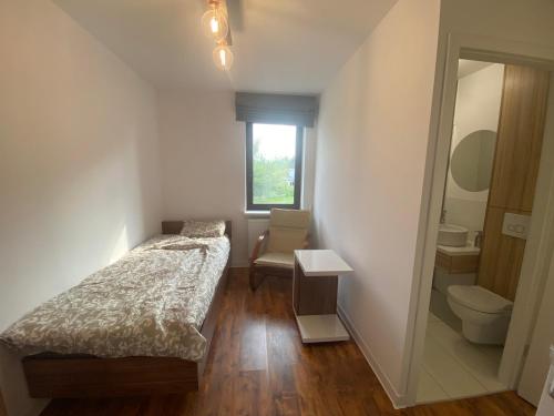 a small bedroom with a bed and a toilet at Miejska Stodoła in Biała Podlaska