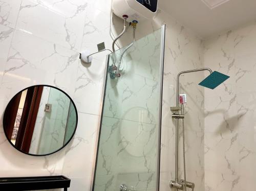La salle de bains est pourvue d'une douche et d'un miroir. dans l'établissement Staycation Loft, Lekki Phase 1, à Lekki