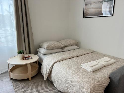 ein kleines Schlafzimmer mit einem Bett und einem Tisch in der Unterkunft Appart Cozy CDG, Paris, Disney, Parc Expo, Astérix in Dammartin-en-Goële
