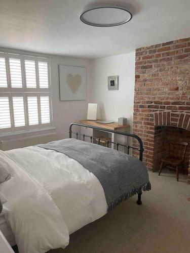 a bedroom with a bed and a brick wall at Stunning Georgian Period House in Kent
