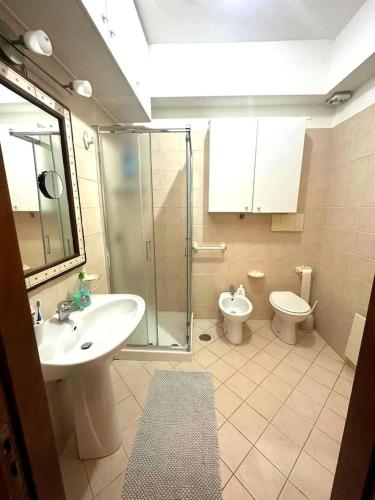 uma casa de banho com um chuveiro, um lavatório e um WC. em Appartamento Cocò em Praia a Mare