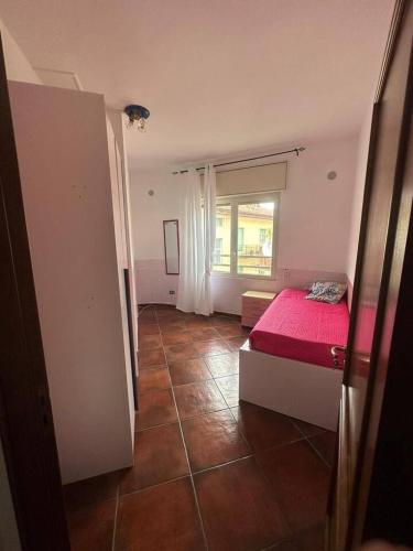 a bedroom with a red bed and a window at Appartamento Cocò in Praia a Mare