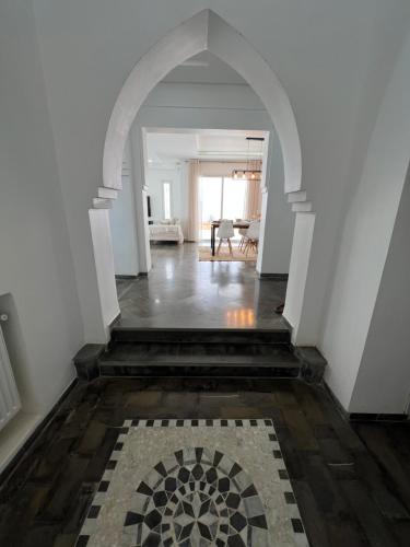 a hallway with an archway and a rug on the floor at Villa Le Domaine Djerba Piscine Chauffée sans vis à vis in Mezraya