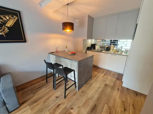 eine Küche mit Tisch und Stühlen in einem Zimmer in der Unterkunft Międzywodzie Plażowa Park Gold in Międzywodzie
