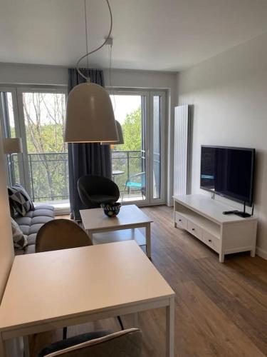 a living room with a tv and a table and chairs at Aura 65 in Katowice