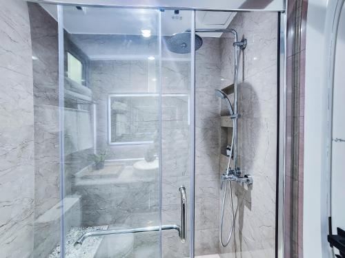 a shower with a glass door in a bathroom at Sunny Canopy in Hulhumale