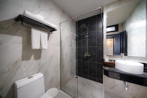 a bathroom with a toilet and a sink and a shower at LHC HOTEL AND RESORT in Pattaya Central