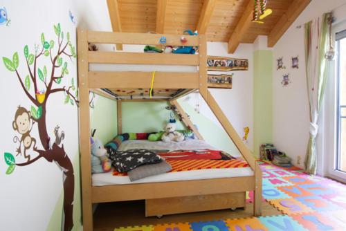 ein Kinderschlafzimmer mit einem Etagenbett mit einem Baumbild in der Unterkunft Ferienhaus Freiheit - Modernes Haus in alpenländischem Stil für Urlaub und Workation in bester Lage am Fuß der Alpen in Oberaudorf