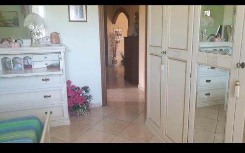 een keuken met witte kasten en een hal met bloemen bij Villa Sabrina in Castro dei Volsci