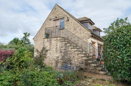 uma antiga casa de tijolos com escadas e uma janela em Exquisite Coach House Near Silverstone & Stowe em Buckingham