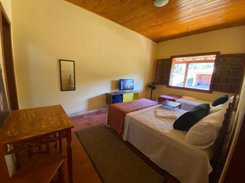 um quarto com 2 camas e uma janela em Casa dos Coqueiros - Cama, Café e Eventos em Itabirito