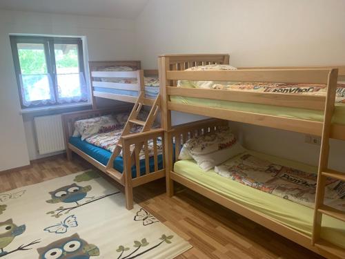 a room with three bunk beds and a window at Ferienwohnung am Ponyhof in Altötting