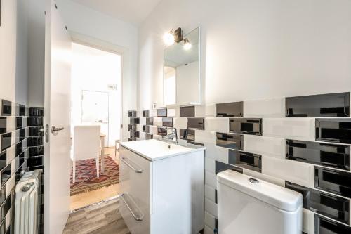 uma casa de banho com um WC, um lavatório e um espelho. em apartamento en plaza de ventas em Madri