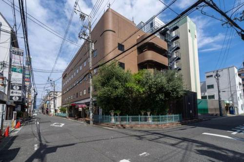 una calle vacía en una ciudad con un edificio en Ramada Encore by Wyndham Amagasaki en Amagasaki