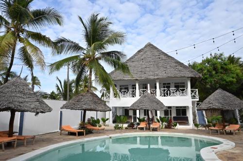 a villa with a swimming pool and palm trees at Ananda Villa Zanzibar in Bwejuu