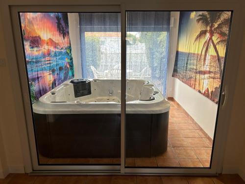 une baignoire dans une pièce avec des portes vitrées dans l'établissement Les Sables d'Olonne, villa de charme, conviviale, idéale en famille ou entre amis - jacuzzi intérieur, à Olonne-sur-Mer