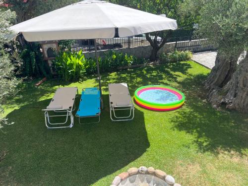 an umbrella and chairs and a frisbee in a yard at TERRY'S VILLA in Makri