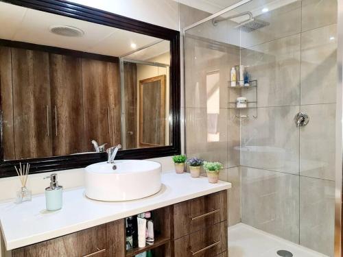 a bathroom with a sink and a shower at Milky Way: Home with large garden, firepit & stars in Kenton on Sea