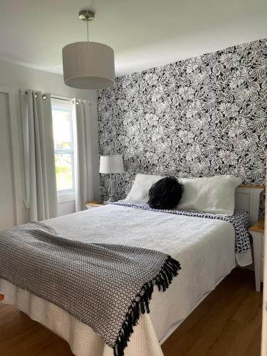 un gato negro acostado en una cama en un dormitorio en Chalets Plage St-Jean 2, en Saint-Jean