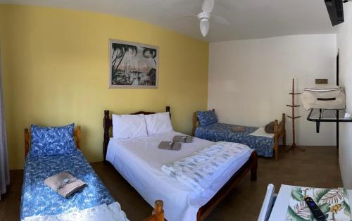 um quarto com duas camas e uma cadeira. em Pousada Cirandinha - P1 em Itajaí